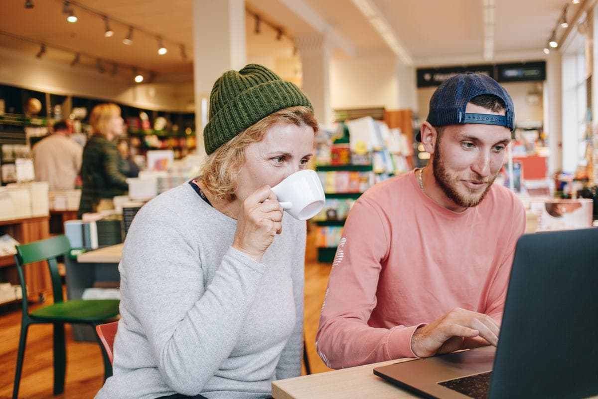 Two people in a shop looking at a laptop together