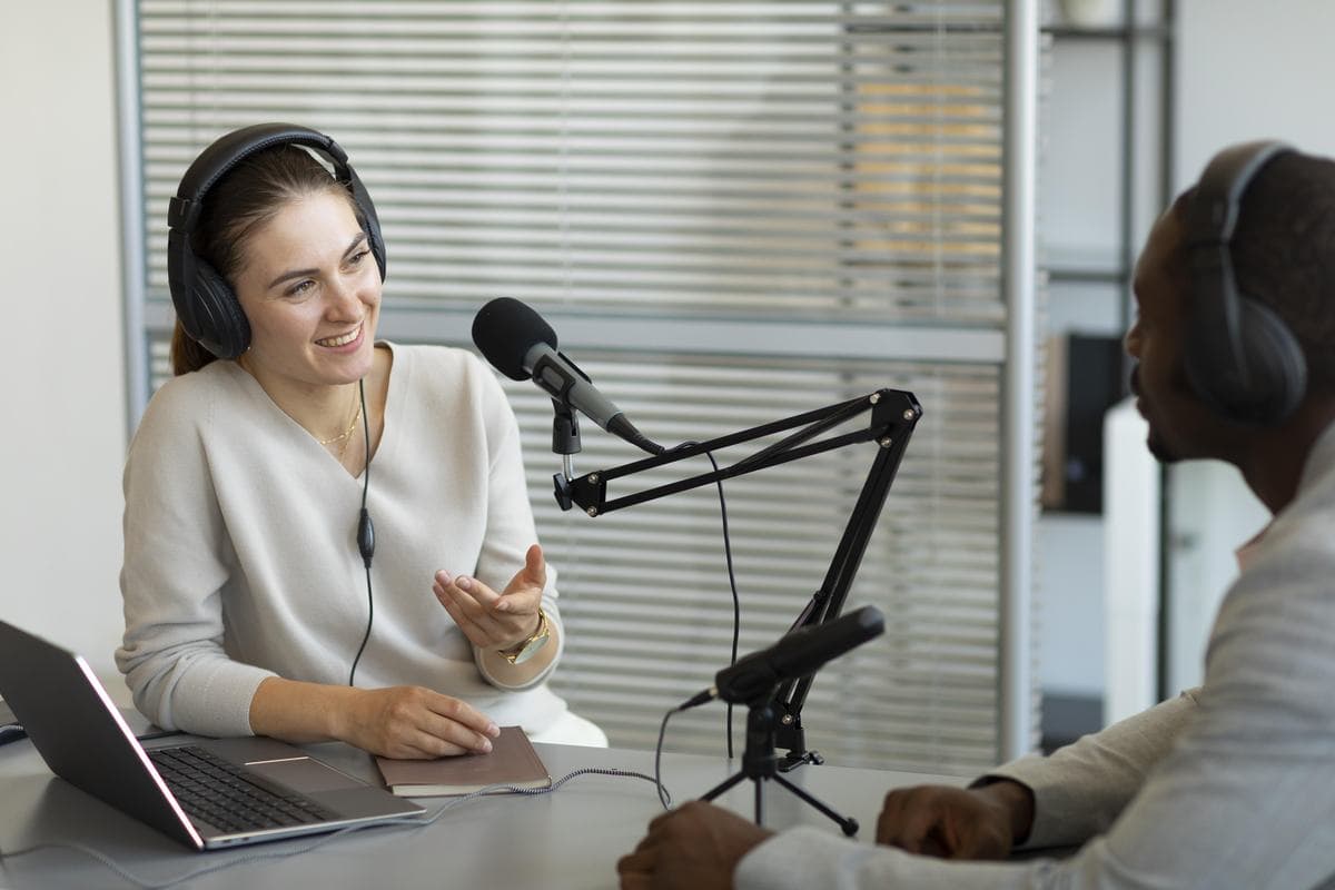 Two people talking across studio microphones